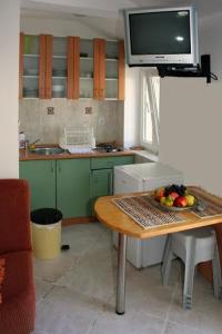 a kitchen with a table with a bowl of fruit on it at Casa M & S in Petrovac na Moru