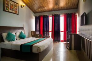 a bedroom with a bed with red and blue curtains at Blue Pine Resort in Lansdowne +70 photos