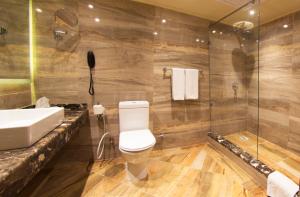 a bathroom with a toilet and a sink and a shower at Pyramisa Suites Hotel Cairo in Cairo