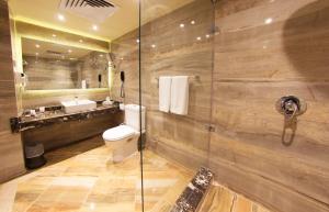 a bathroom with a toilet and a glass shower at Pyramisa Suites Hotel Cairo in Cairo