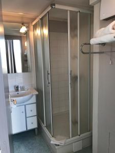 La salle de bains est pourvue d'une douche et d'un lavabo. dans l'établissement Hôtel Residence Les Aiguades, à Port-de-Bouc