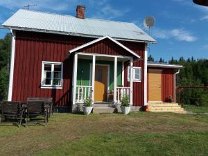 een rood huis met een gele deur op een veld bij Stuga på landet in Gunnarskog