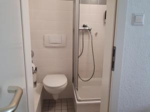 a small bathroom with a toilet and a shower at Hotel Taverne Inos in Hannover