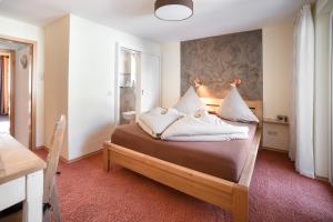 a bedroom with a bed with white pillows on it at Haus Quentin in Willingen