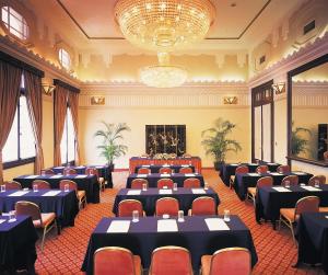 a room with rows of tables and chairs and a chandelier at Okura Garden Hotel Shanghai in Shanghai +48 photos