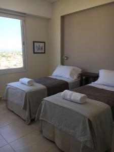 a hotel room with two beds with towels on them at Departamento moderno centrico, vista ciudad, valle y montañas in Salta