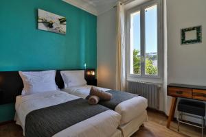 two beds in a room with a green wall at Hotel La Villa Florida in Bandol