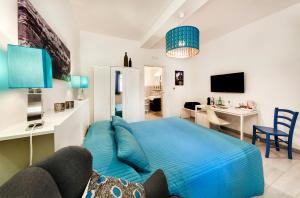 1 dormitorio con 1 cama azul y sala de estar en siciliacasevacanze - Marina Domus Rooms, en Marina di Ragusa