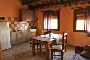 a kitchen with a table and chairs and a refrigerator at casarosana in Deltebre