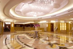 a large lobby with a large chandelier and a vase with flowers in at Okura Garden Hotel Shanghai in Shanghai