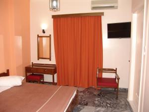 a bedroom with a bed and a desk and a red curtain at Hotel Cosmos in Athens
