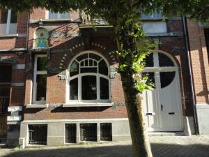 a brick building with a white door and a tree at Villa Tournesol in Tournai +9 photos