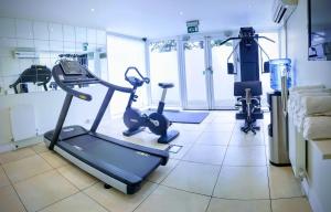 a gym with a treadmill and an exercise bike at Stanwell Hotel By Mercure in Stanwell