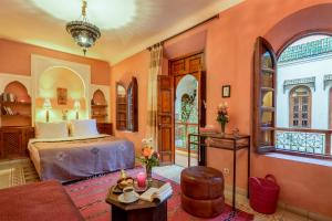Un dormitorio con una cama y una sala de estar. en Riad Sable Chaud, en Marrakech 52 fotos más