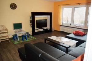 ein Wohnzimmer mit einem Sofa und einem Flachbild-TV in der Unterkunft Ferienhaus Zur Edertalsperre in Edersee