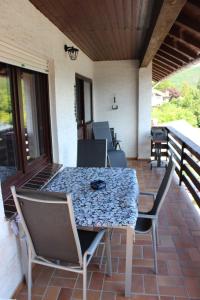 eine Terrasse mit einem Tisch und Stühlen auf einer Veranda in der Unterkunft Ferienhaus Zur Edertalsperre in Edersee