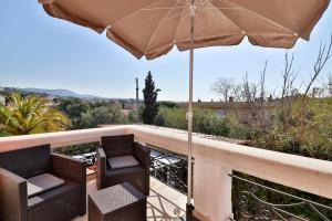 a balcony with two chairs and an umbrella at Hotel La Villa Florida in Bandol