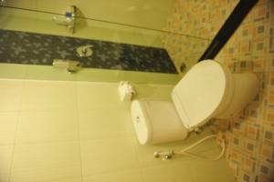 a bathroom with a white toilet in a room at Hotel Jolin in Makassar