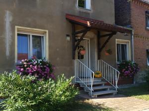 eine Veranda eines Hauses mit einer Treppe und Blumen in der Unterkunft Ferienwohnung Rampitz in Rampitz