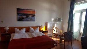 Hotel Seerose في فيلهلمسهافن: غرفة فندق بسرير وبطانية حمراء
