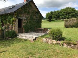 a stone house with a table and chairs in the yard at Maison Bleue in Lavault-de-Frétoy