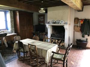 a dining room with a table and a fireplace at Maison Bleue in Lavault-de-Frétoy