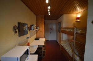 Habitación pequeña con escritorio y literas. en Studio Room, en Celerina