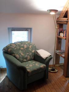 ein Wohnzimmer mit einem Stuhl und einer Lampe in der Unterkunft Bauernstube Scheidterhof in Kobern-Gondorf
