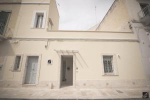 a white building with two doors and two windows at Kees Apulian Stay in Monopoli