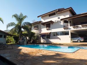 a house with a swimming pool in front of a house at Hotel Nova Odessa - OFICIAL in Nova Odessa