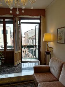 een woonkamer met een bank en een groot raam bij Residenza Ca Trinità in Venetië