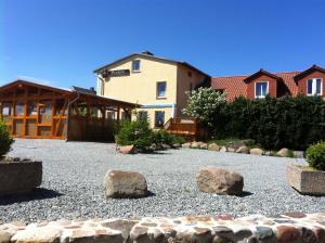 a house with rocks in a gravel yard at Hotel-Pension Zur Mole in Wiek auf Rügen