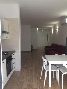 a kitchen and a living room with a table and chairs at Residence al Pino in Matera