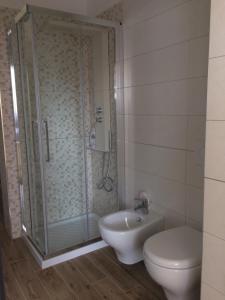 a bathroom with a shower and a toilet and a sink at Residence al Pino in Matera +31 photos