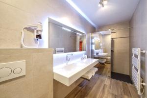 een badkamer met een wastafel en een grote spiegel bij Au fil de l'eau in Seneffe