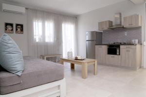 a living room with a couch and a kitchen at R&K Suites in Keramoti