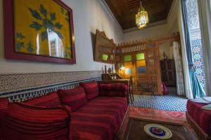 a living room with a red couch in a room at Riad Dar Cordoba in Fès