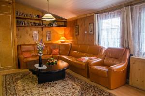 a living room with brown leather furniture and a table at Marina Bajana in Mikołajki