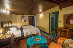a bedroom with a bed and a table in a room at Riad Dar Cordoba in Fès