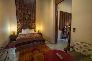 a bedroom with a bed and a couch in a room at Riad Dar Cordoba in Fès