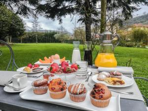 una mesa cubierta con magdalenas, fruta y zumo en Relais Corte Rodeschi, en Camaiore