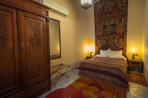 a bedroom with a bed and a large wooden cabinet at Riad Dar Cordoba in Fès