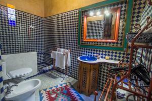 a bathroom with a toilet and a sink and a mirror at Riad Dar Cordoba in Fès