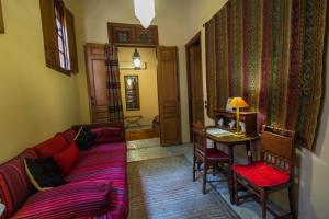 a living room with a couch and a table at Riad Dar Cordoba in Fès