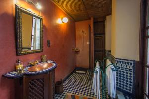 a bathroom with a sink and a mirror at Riad Dar Cordoba in Fès