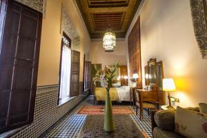 une chambre d'hôtel avec un lit et un vase de fleurs dans l'établissement Riad Dar Cordoba, à Fès