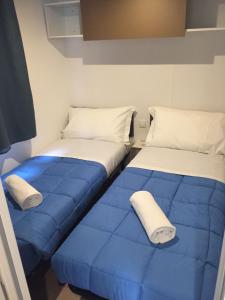 dos camas sentadas una al lado de la otra en una habitación en Camping Village Città di Milano, en Milán