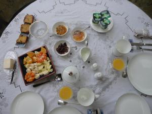 einem weißen Tisch mit Teller und Schüsseln aus Essen in der Unterkunft Villa Tournesol in Tournai