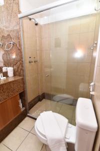 a bathroom with a toilet and a glass shower at Mirador Praia Hotel in Natal