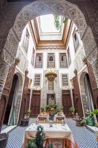 a large room with tables in a building with a ceiling at Riad Dar Cordoba in Fès